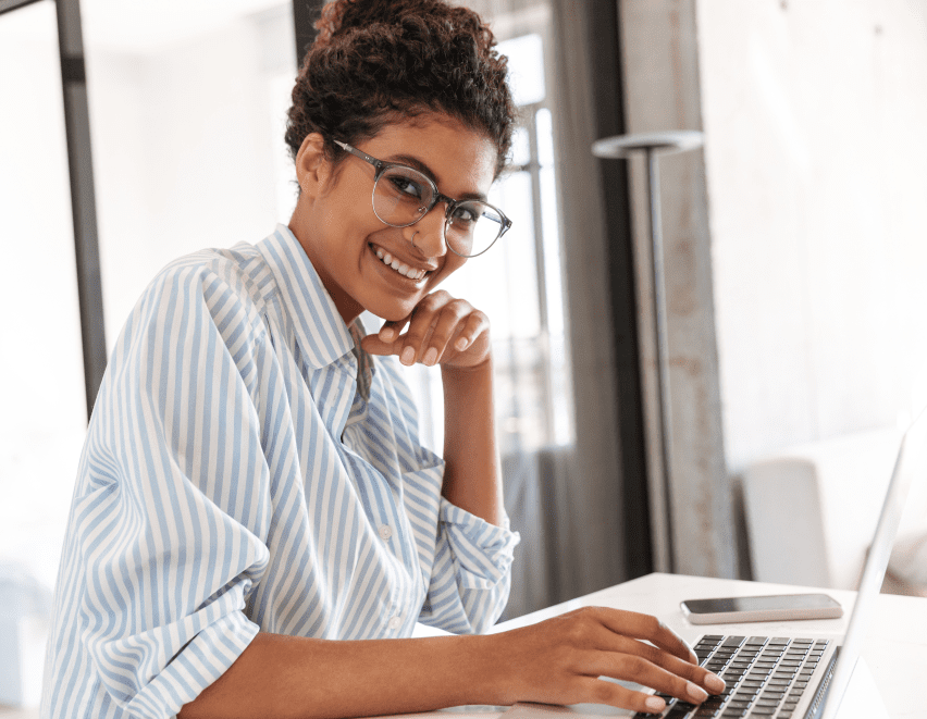 Image of a woman sitting with a laptop and smiling